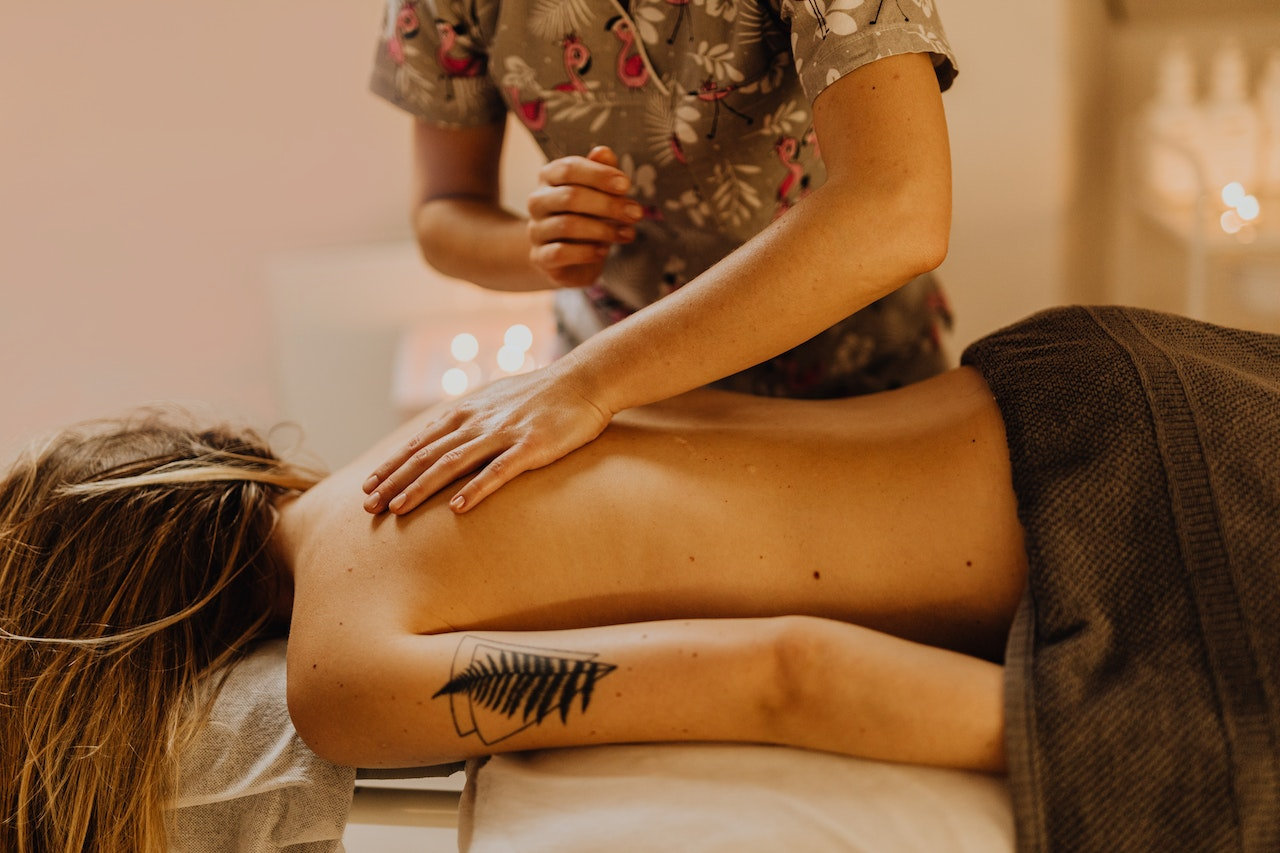 Massage therapists hand placed on client's back during treatment